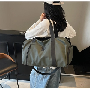 Model showing olive green travel bag with wide black straps and separate shoe compartment