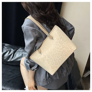 Dettaglio della borsa tote leopardata con hardware in metallo argento e doppi spallacci