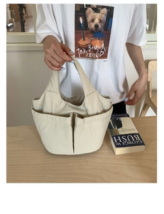 Close-up of cream multi-pocket fabric handbag on a wooden table for daily use