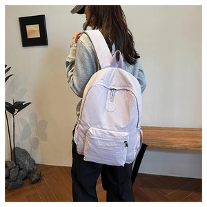 Vue lifestyle d'un sac à dos lavande porté par un mannequin dans une pièce minimaliste