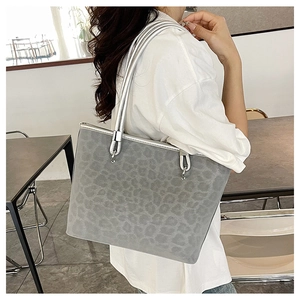 Dettaglio della borsa tote grigia leopardata con manici metallici argentati lucidi