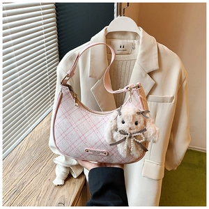 Pink plaid shoulder bag with plush bunny charm and metallic logo tag detail