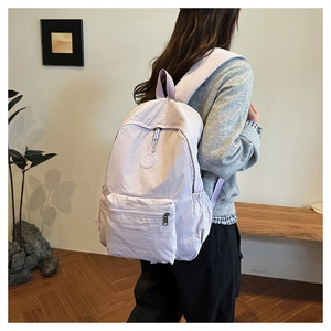 Vue latérale d'un sac à dos décontracté en nylon violet clair porté par un mannequin
