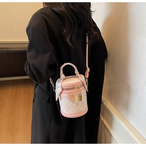 Detail of pink plaid bucket bag with silk scarf handle and golden padlock charm