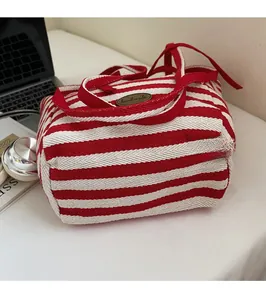 Macro shot of red and white striped canvas tote with handmade tag and Laptop