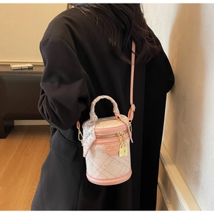 Pink quilted bucket bag detail with heart-print silk scarf handle and golden lock charms