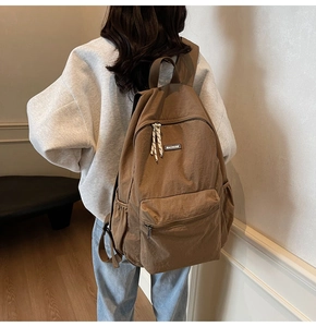 Rear view of brown minimalist nylon backpack showing large capacity and side pockets