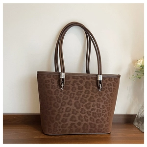 Dettaglio della borsa tote leopardata con trama scamosciata e manici in pelle
