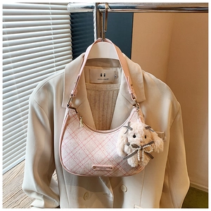 Detailed texture of pink tweed crescent hobo bag with cute plush rabbit charm
