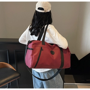 Detail of red versatile travel bag with NICE DAY logo and adjustable shoulder strap