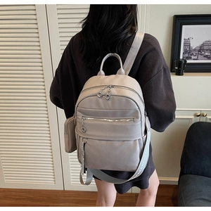 Detail of light grey lychee texture backpack with small pouch and wide strap for women