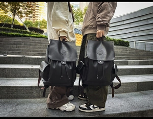 Detail view of black PU leather backpack showing pebble texture and flap closure