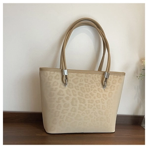 Dettaglio della borsa tote leopardata con fibbie metalliche argentate e manici robusti