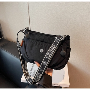 Close-up of the black nylon crossbody bag featuring a jacquard logo wide shoulder strap