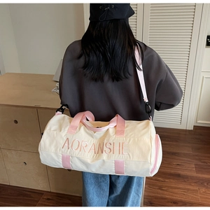 Spacious off-white travel bag with pink handles shown on a model in a cozy interior