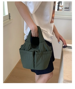 Close-up of olive green multi-pocket nylon bucket bag with practical side storage