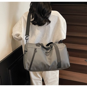Detailed view of dark gray travel bag with waterproof nylon texture and wide strap