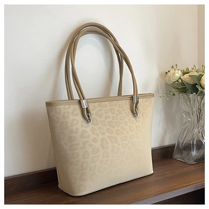 Dettaglio della borsa tote leopardata con fibbie in metallo argento e texture scamosciata