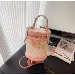 Detailed shot of pink bucket bag with quilted patterns and silk scarf handle detail