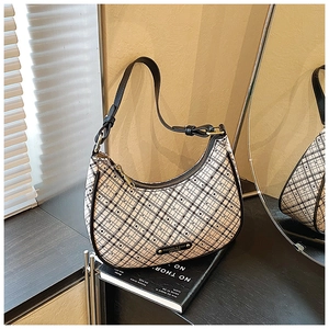 Detailed close-up of a plaid crescent shoulder bag featuring premium leather strap and hardware