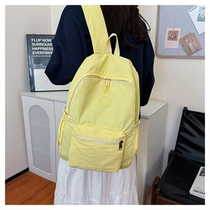 Sac à dos décontracté jaune clair porté par un modèle dans un intérieur moderne