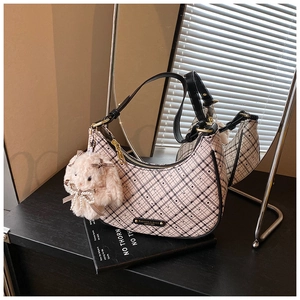Detailed close-up of pink checkered armpit bag with cute plush bunny pendant and pearl bow