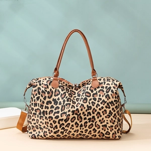 Detailed side view of leopard print travel bag with brown leather handles and strap