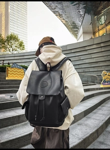 Detailed view of black vintage leather backpack with drawstring and magnetic closure