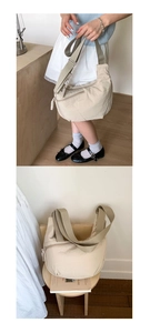Detail of beige half-moon crossbody bag with adjustable wide strap and front zipper
