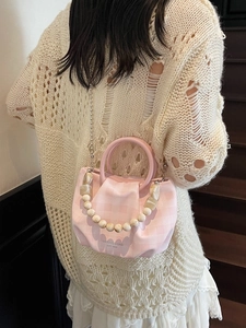 Borsa a nuvola plissettata a quadri rosa con tracolla di perline su una modella