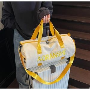 Detail of travel duffel bag with yellow AORANSHE embroidery on silver metal suitcase