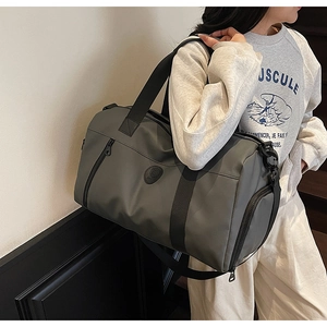 Detail of dark grey travel duffel bag with water-resistant nylon and adjustable shoulder strap