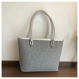 Dettaglio della borsa tote leopardata grigia con manici in metallo argento e texture opaca
