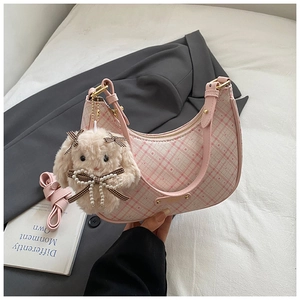 Detail of pink plaid hobo bag with a cute plush rabbit charm and pearl decoration
