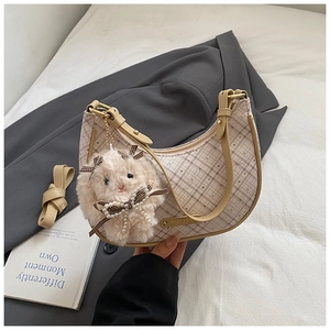 Detail of beige plaid crescent bag with pearl bunny charm and adjustable strap