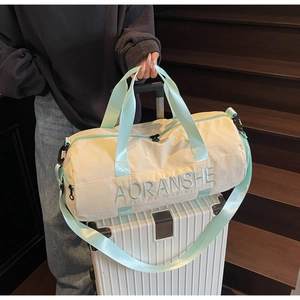 Travel bag with mint green straps shown mounted on a white suitcase handle