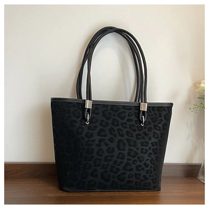 Dettaglio della borsa tote leopardata con texture scamosciata e manici neri tondi