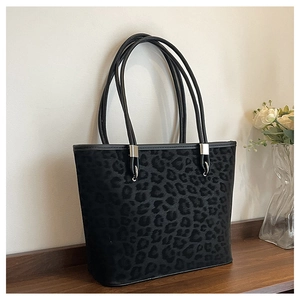 Dettaglio della borsa tote leopardata con cinturini in pelle nera e fibbie argentate