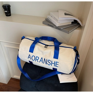 Detail of a large white and blue travel bag with dual zippers and woven straps