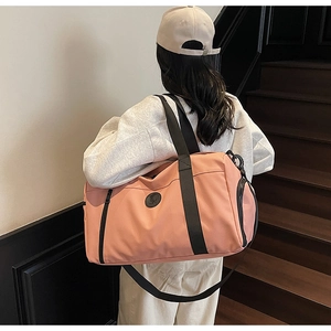 Detail of peach pink travel bag with side shoe compartment and black woven handles