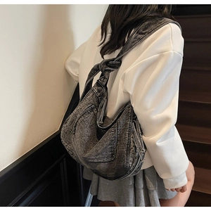 Detail shot of vintage washed denim hobo bag with stylish knotted strap design