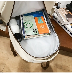 Top view of large capacity cream backpack main compartment showing internal storage space