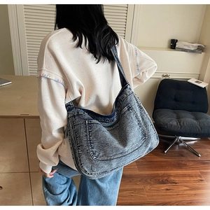 Close-up of large vintage wash denim tote bag showing thick texture and pocket detail