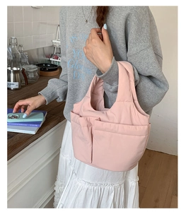 Close-up of pink quilted tote bag with multi-pocket design in a lifestyle setting