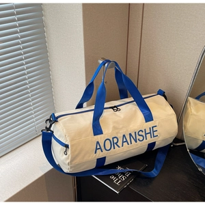 Detail of a beige canvas gym bag with blue straps and adjustable shoulder strap