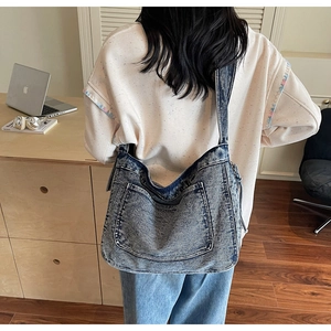 Detailed back view of a large washed denim tote bag with laptop for daily commute