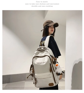 Detail of white large capacity backpack with leather trim and plush duck pendant