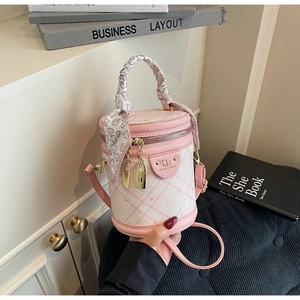 Detailed view of pink plaid bucket bag featuring silk scarf handle and golden hardware