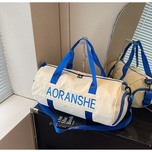 Close-up of cream canvas travel bag with bright blue straps and brand logo details