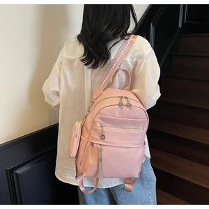 Close-up of pink faux leather backpack with litchi texture and detachable side coin purse